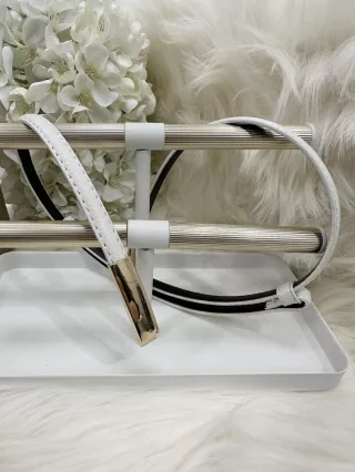   Curea din piele ecologică, subțire, cu cataramă metalică ajustabilă.